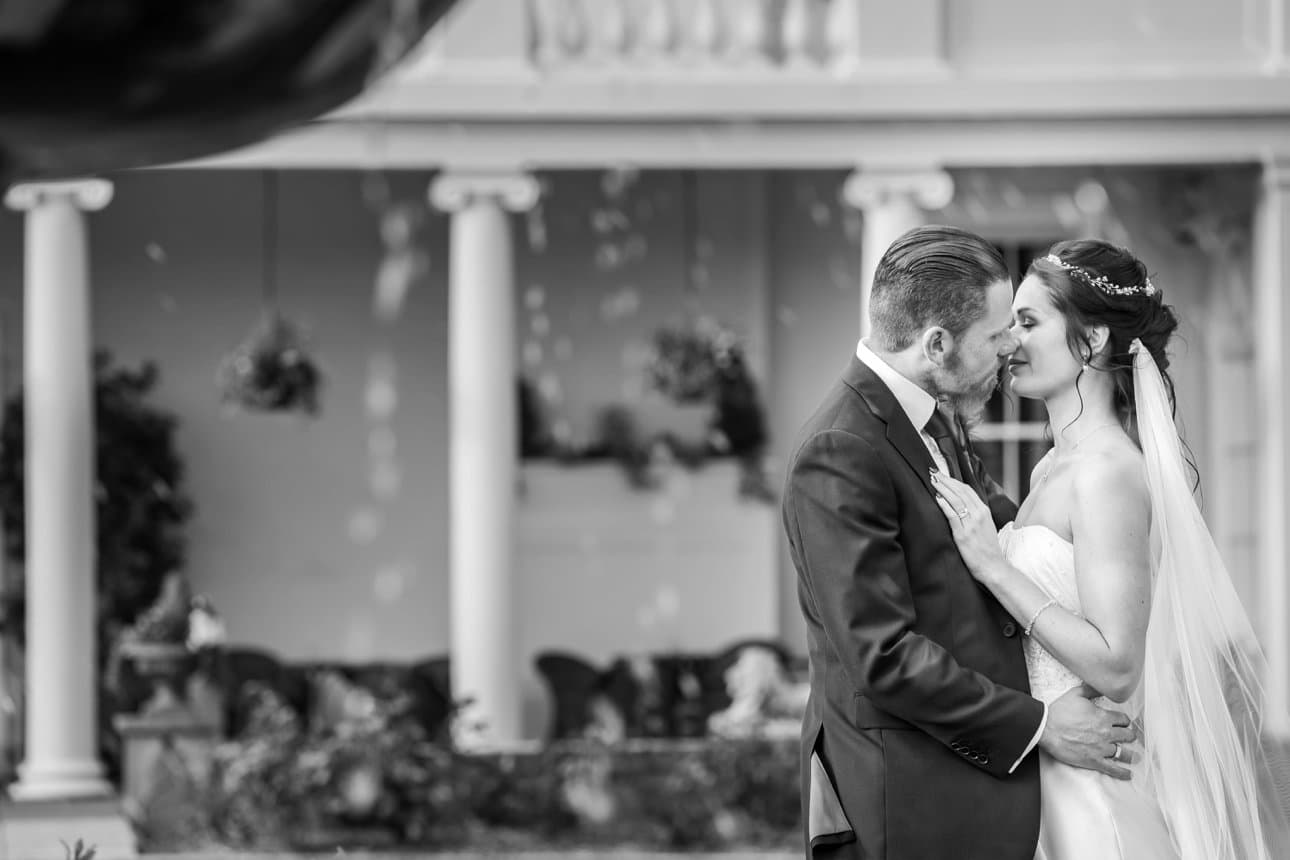 The bride and groom kiss during their wedding portraits at The Lawns, Rochford, an Essex wedding venue that allows exclusive use for your wedding day. 