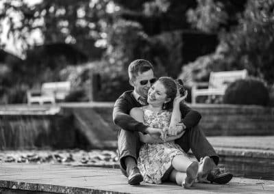 engaged-couple-cuddling-together-by-waterfall-at-the-grove-gardens
