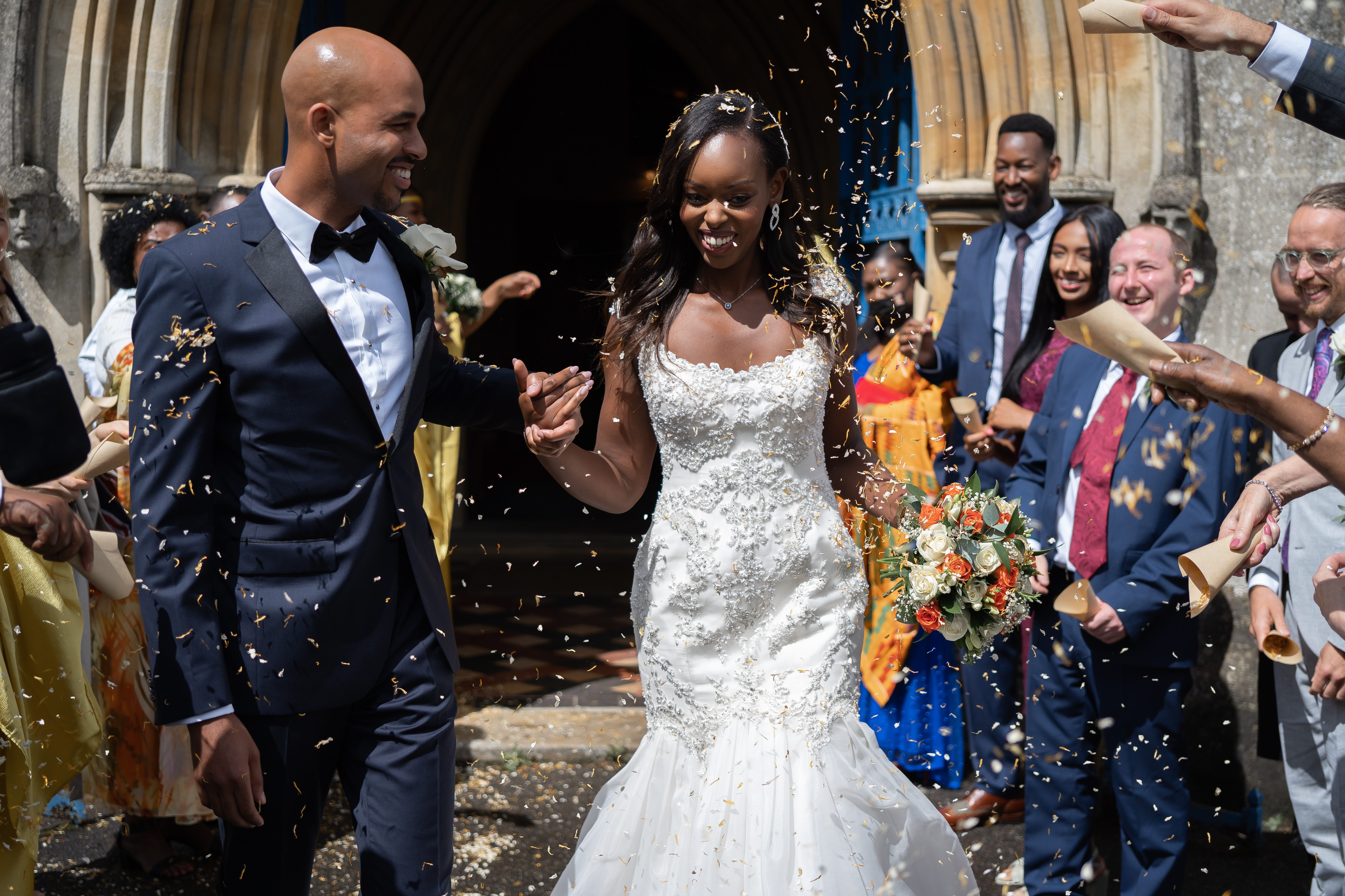 bride-and-groom-walking-through-confetti-at-the-church-hertfordshire