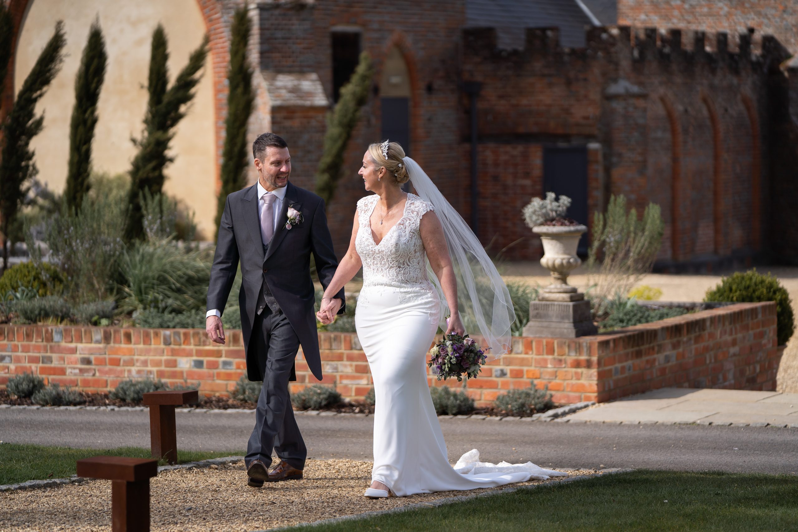 bridal-couple-walking-holding-hands-at-wasing-park-berkshire