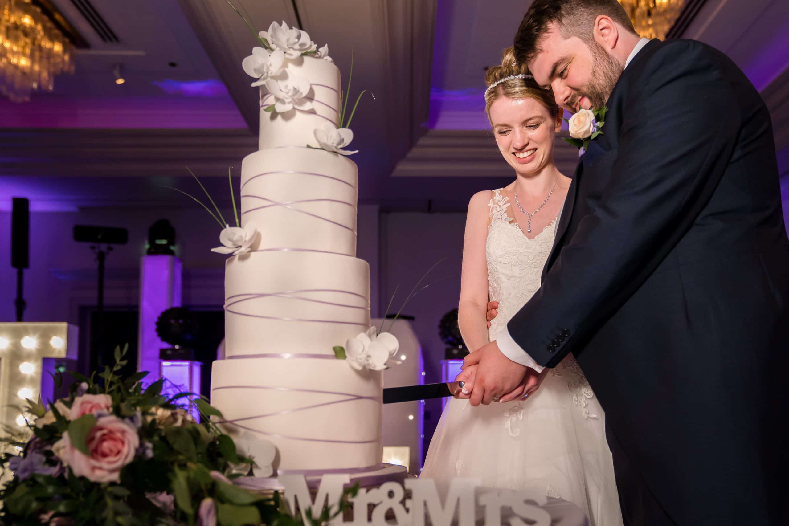 couple-cutting-wedding-cake-at-sopwell-house-st-albans